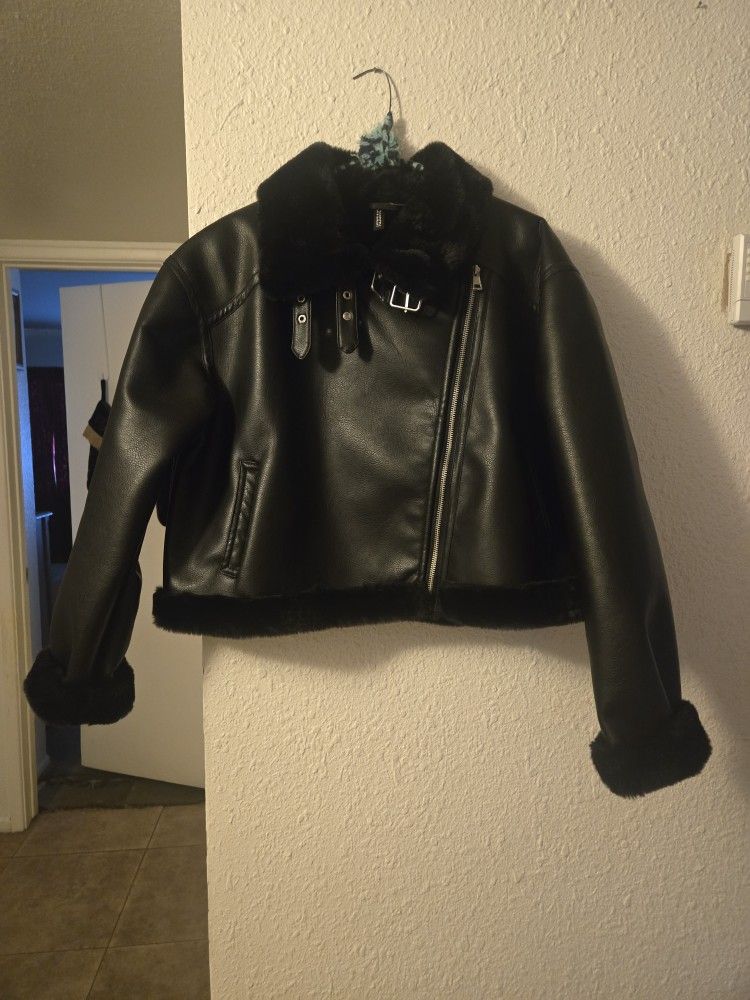 Black faux fur lined leather jacket with belt detail. Size: M