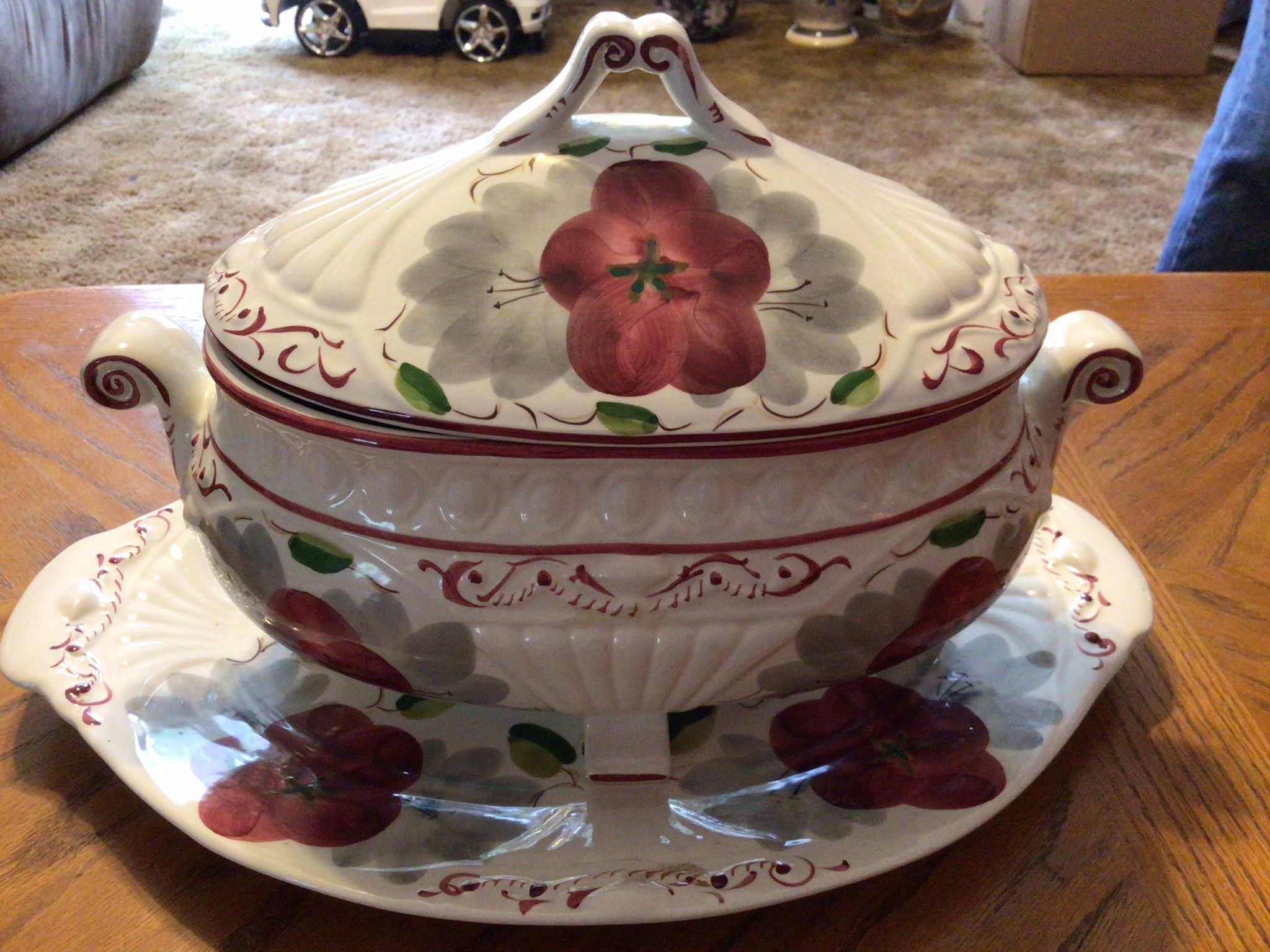 A vintage large 10" wide Chinouserie decorative multi colored floral bowl of pinks, yellow, green and purple. It has a blue background and a gold rim.