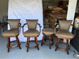 Three swivel bar stools with back support and one high stool