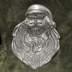  Vintage metal Santa Claus face tray featuring a detailed classic Santa design with flowing beard and traditional hat. Solid cast construction with a 