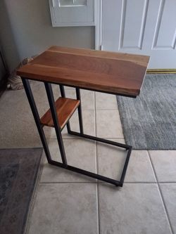 Wooden C table with black metal frame and lower storage shelf