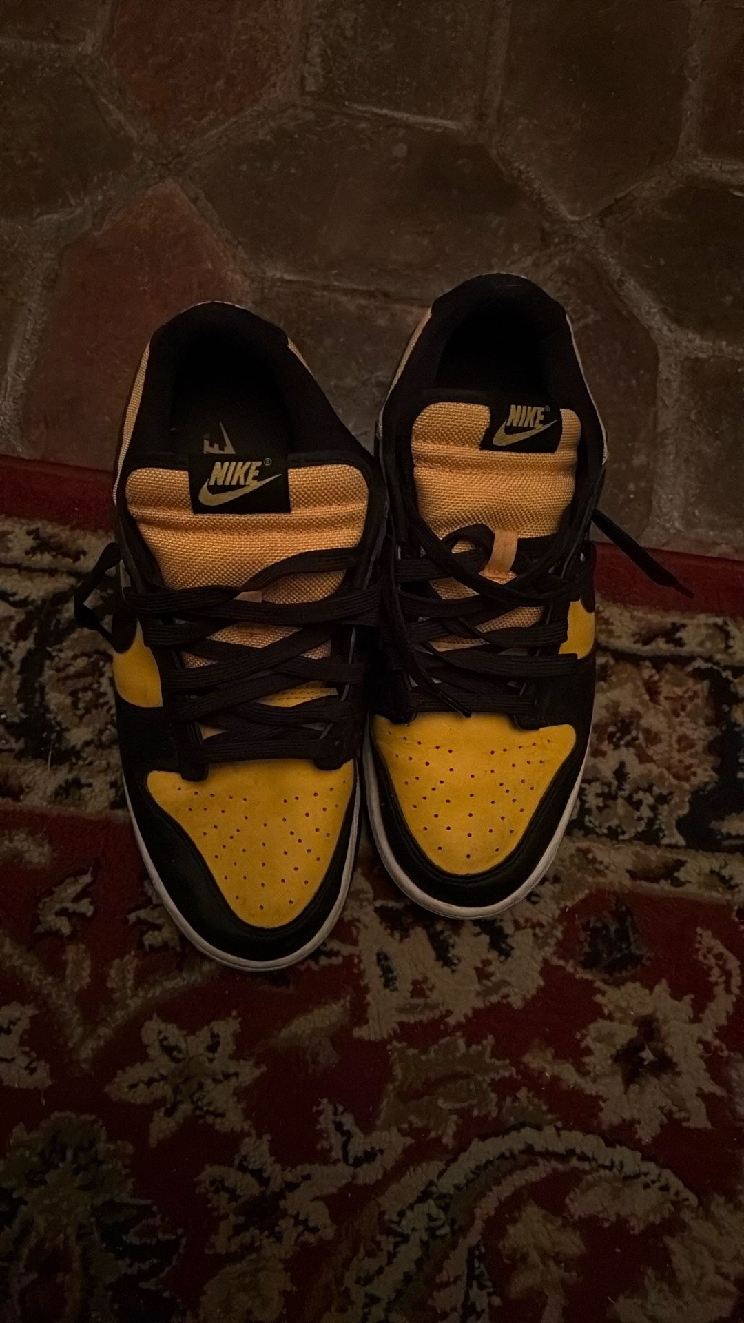 This is a Nike Dunk Low "Reverse Goldenrod" sneaker with a black and university gold leather upper.
