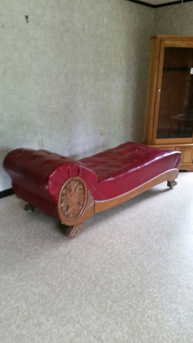 Victorian fainting couch, oak trim, wooden casters and red naugahyde button tuffed cover. No significant damage to cover, in great condition. Old old