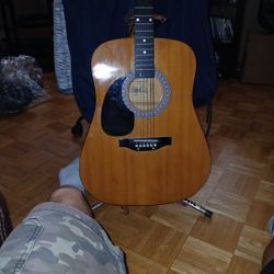And\nBurns wood acoustic guitar with a ultra stand