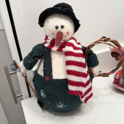 Snowman figurine holding a shovel and wreath 12 inches