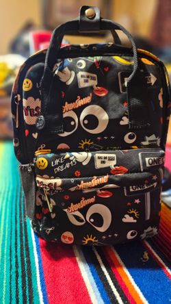 mochila negra con estampado de emojis y diseño tipo cómic de la marca Like Dreams
