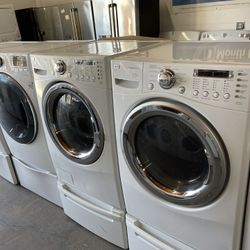 LG front load washer and electric dryer on a pedestal