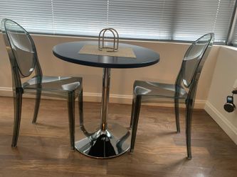 Round small table with two clear gray chairs