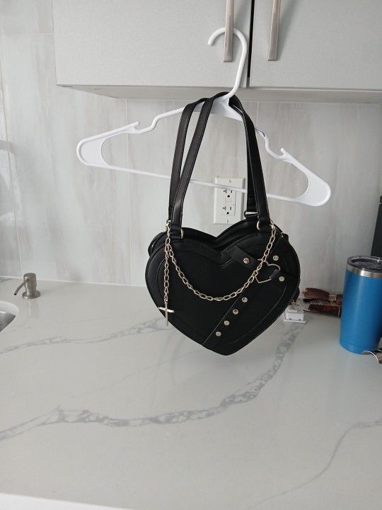 Selling a black heart purse with a ✝️ on it