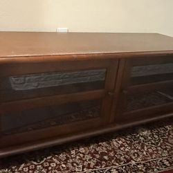 Wood tv stand with glass door big cabinets 54"x 19"x18" Cabinets are big for keep lots of stuff in it Solid wood tv stand Excellent condition