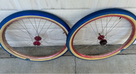 SE bmx 29in faded red wheels with blue tires.
