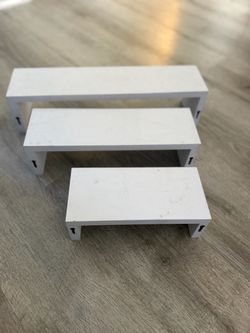 Set of 3 EWEI’S HomeWares white floating U-shaped shelves in three different sizes.