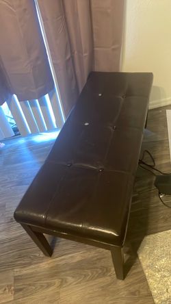 Leather ottoman in good shape with dark wood