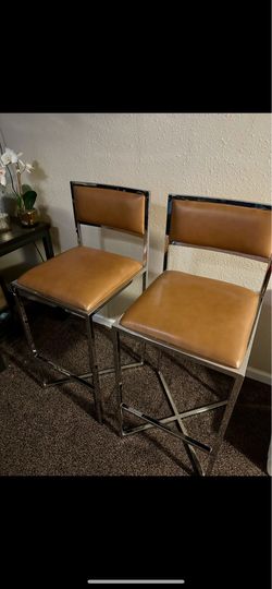 Two brown bar stools with backs