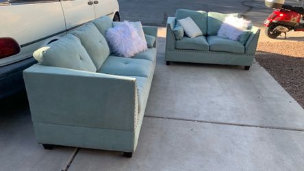 Sea foam green Sofa and loveseat with pillows.