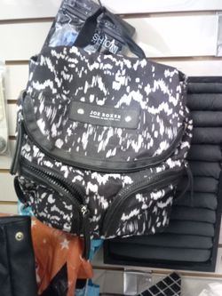 Joe Boxer Original of New York sling/shoulder purse features a black and white abstract pattern with multiple zippered pockets for organization. 