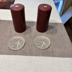 Two large candles with glass holders