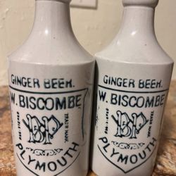 Pair of antique white glazed stoneware W. Biscombe ginger beer bottles