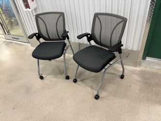 Two Global Roma Nester mesh back chairs- featuring a flip-up seat and silver casters.