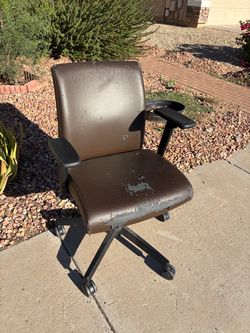 Scratched up brown leather office chair