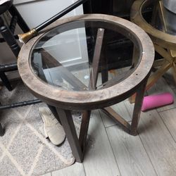 This item is an accent table with a glass top and a wooden base, which appears to be from Ashley Furniture.