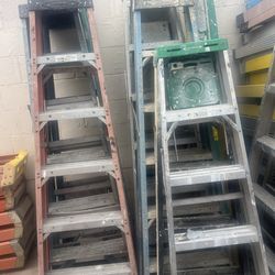 Escaleras de seis pies de aluminio y de fibra de vidrio, $60 cada una