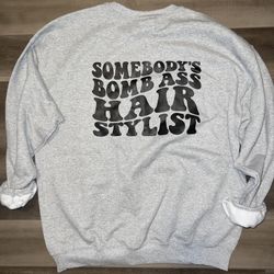 SOMEBODY’S BOMB ASS HAIRSTYLIST GRAY CREW SWEATSHIRT UNISEX