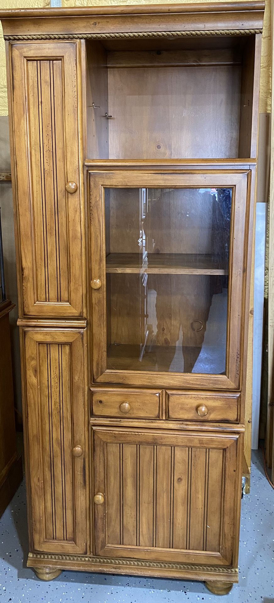 Glass and wood cabinet very sturdy and heavy. Lots of storage.