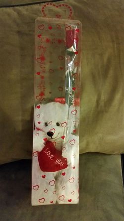 Teddy bear in a box with rose