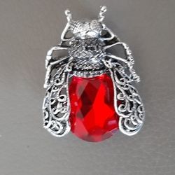   Insect Brooch with a red gem & silver tone detailing.