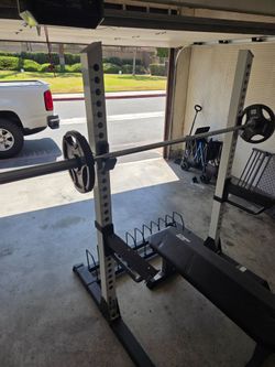 Squat racks  with 25 pound weights barbell an bench