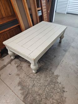 Large  farmhouse-style coffee table with a plank-look top and chunky turned legs.
