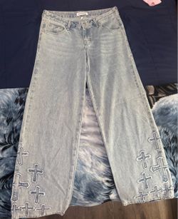 light wash low rise jeans with crosses on the bottom.