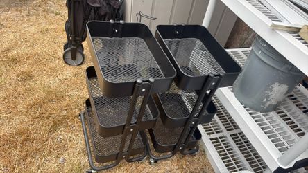 Two black metal carts with three shelves