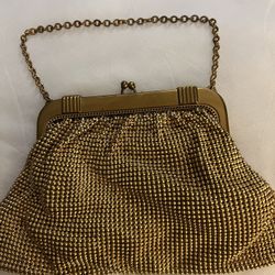 This item is a vintage Whiting & Davis gold tone mesh bag, likely dating from the 1940s to 1950s based on its structured frame and Art Deco style clas