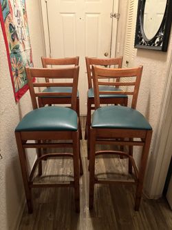 See if 4 wooden bar stool whit teal upholstered seat