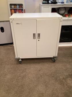 White metal cabinet on wheels. Dimensions height 34 inches width 32 and a half.