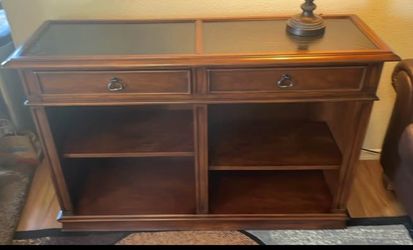 Wood entourage with shelves and drawers.