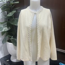 This elegant cream sweater features exquisite pearl detailing along the neckline. Perfect for adding a touch of sophistication to any outfit.  Vintage
