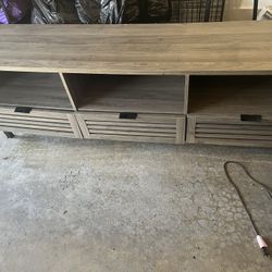 To end tables and a 70 inch TV stand and another wooden table