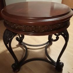 Round Wood/Metal Table Used as end or coffee table. Carved wood accent trim. 