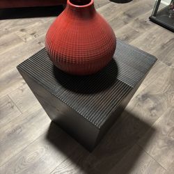 Red Textured Vase on Black Wooden Storage Cube