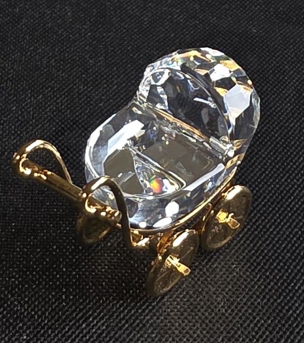 Swarovski Crystal Memories baby carriage figurine with 18K gold-plated accents. 