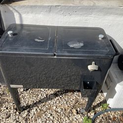 PERMASTER  BLACK  METAL  TOP LOADING COOLER  ON  LEGS  - WITH REAR DRAIN WITH SCREW IN STOPPER -BOTTLE CAP OPENER & CATCHER IN FTONT
