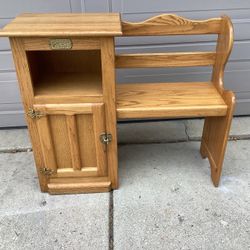 vintage-style oak telephone bench, also traditionally known as a gossip bench or hall seat.  This specific piece features a built-in storage cabinet a