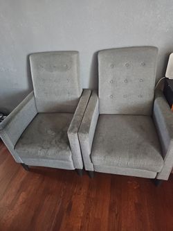 Two gray single recliner sofas.