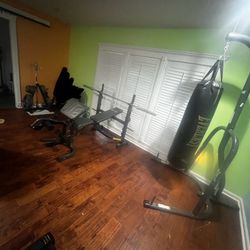 Olympic weight bench with weight rack curl bar and punching bag 