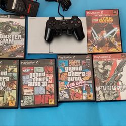 Silver PlayStation 2 Slim console with 6 video games and controller tested
