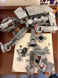Partially-assembled LEGO Star Wars AT-AT set 75288. This gray plastic building kit includes the main walker body, detached leg sections, and various l