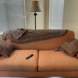 Orange Sofa With 2 Multicolored Design Pillows